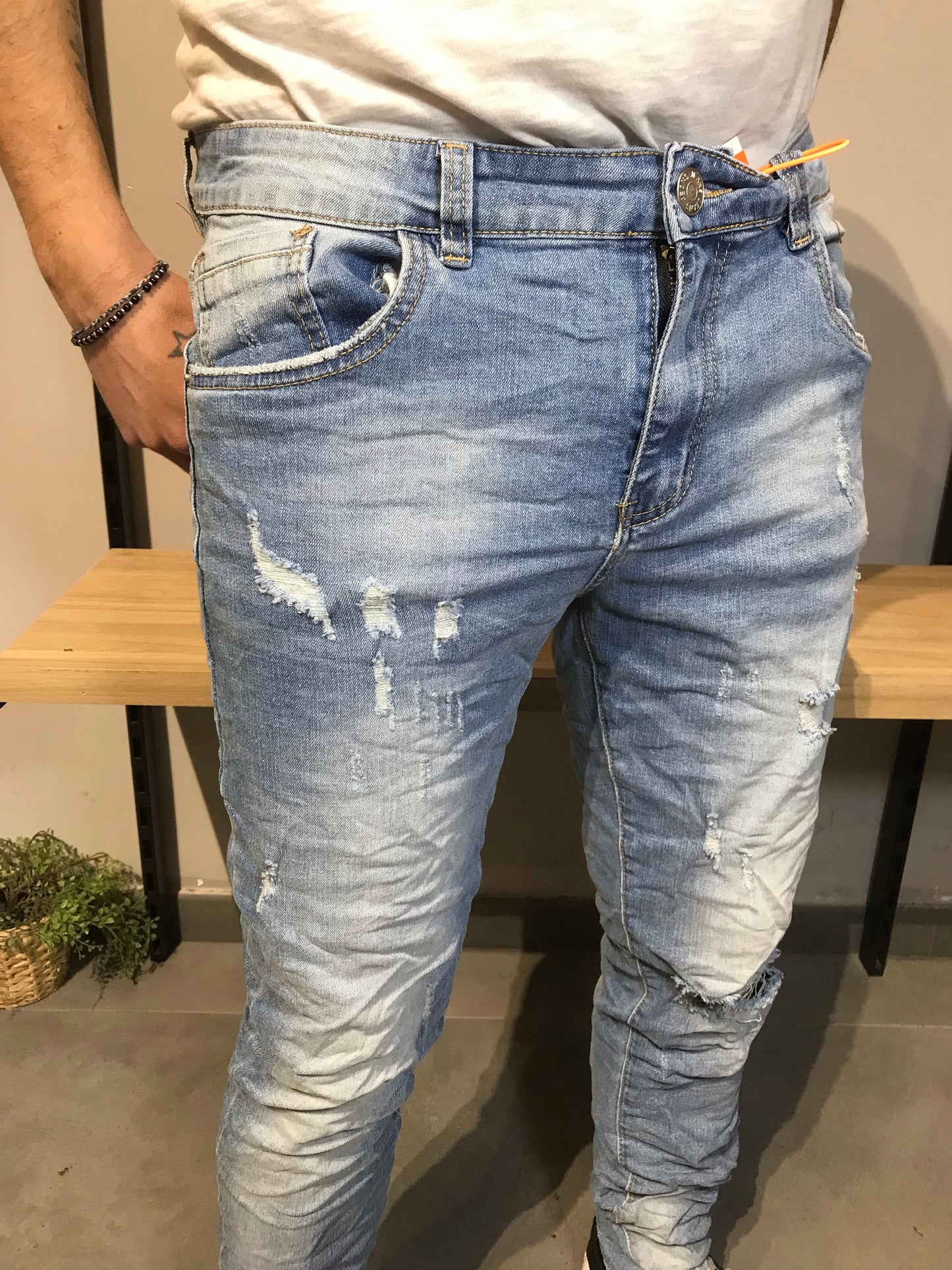 Jeans chiari da uomo stile vintage con piccoli strappi, perfetti per un look casual e alla moda.