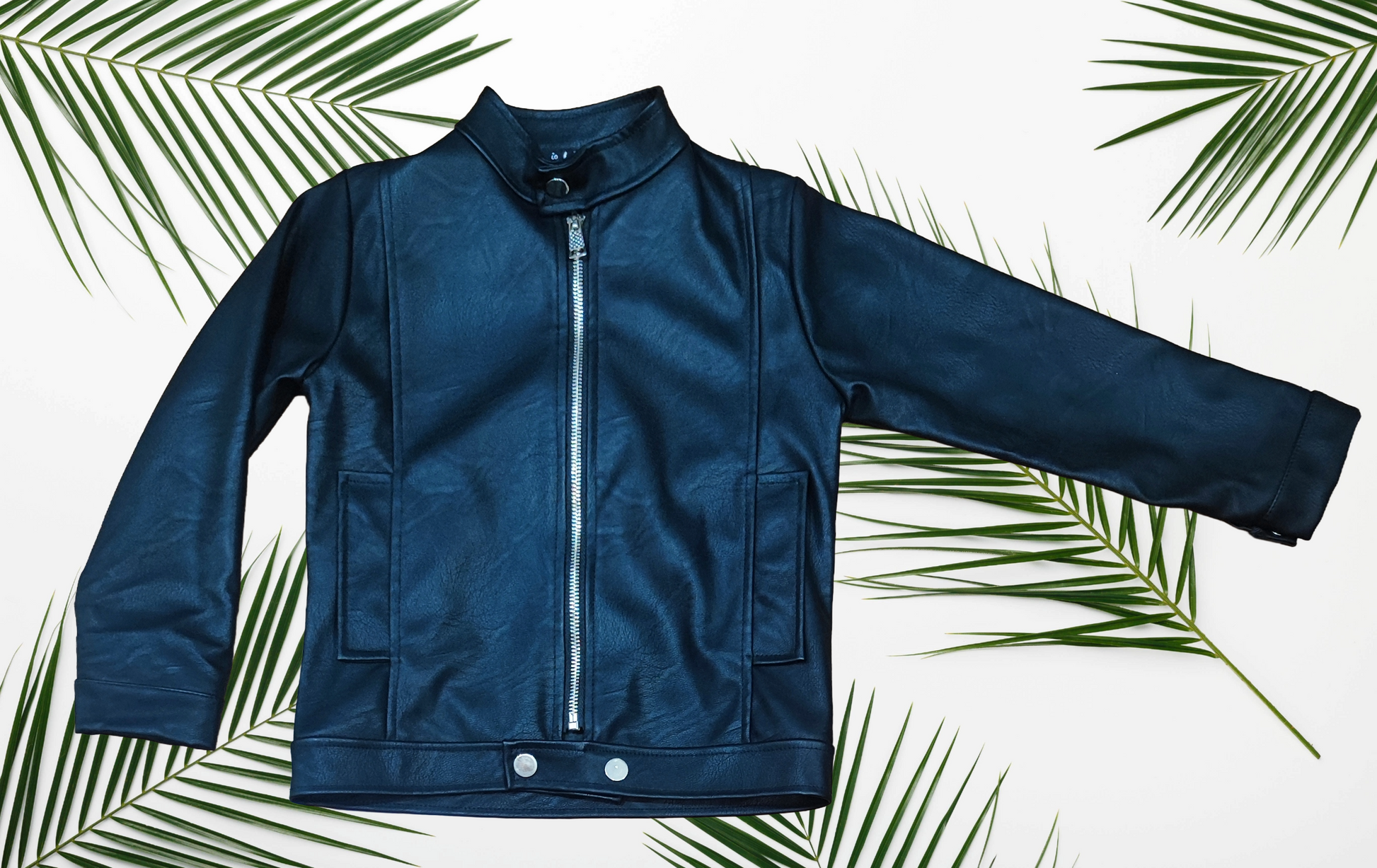 Dettaglio giacchetto bambino similpelle nero con zip e tasche, perfetto per outfit casual mezza stagione